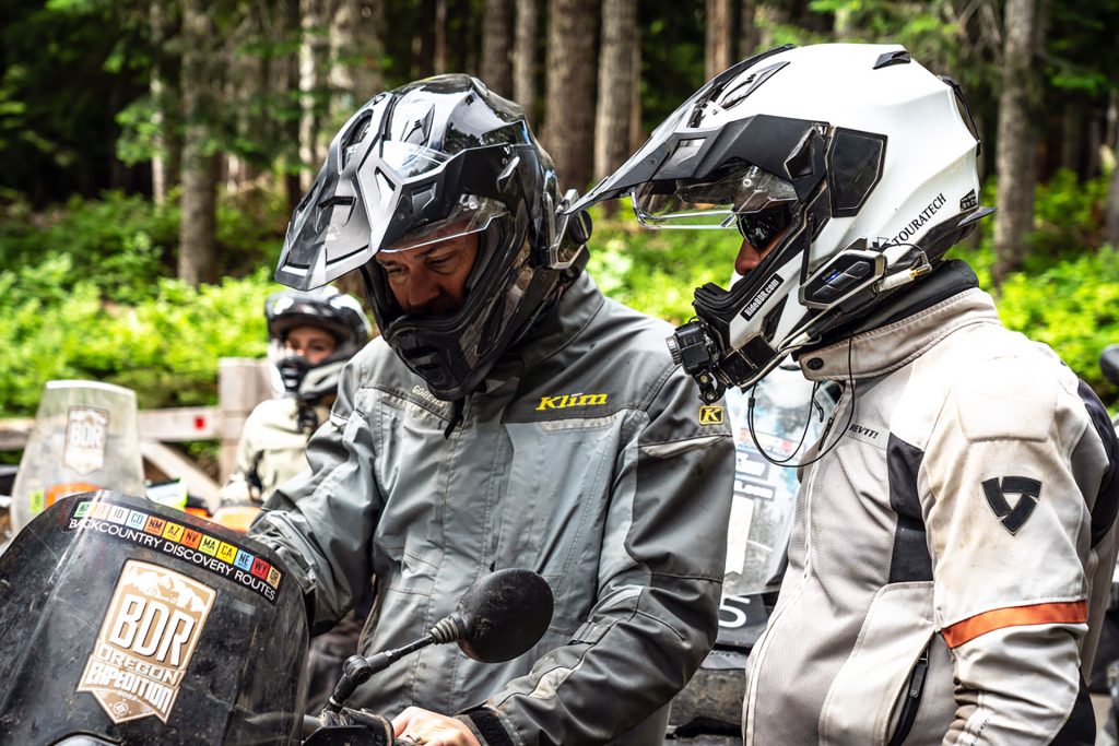 Two riders of BDR's expedition team are having a discussion, each wearing a helmet equipped with Sena 50S and 50C.